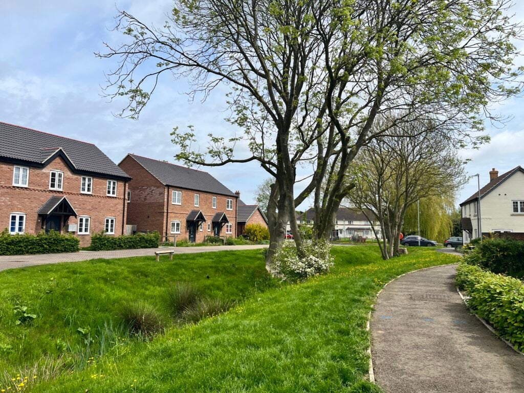 New residential estate that used the site's existing features as part of their landscaping and drainage design. Shows houses with frontage footpath adjacent to trees within a small watercourse.